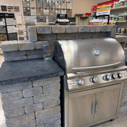 A propane grill and stone bar on display inside of Rainbow Ag.