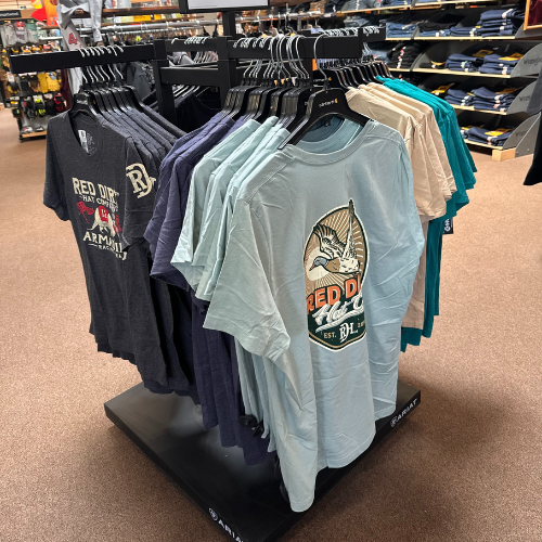 Shirts hung up on clothing racks inside of Rainbow Ag.