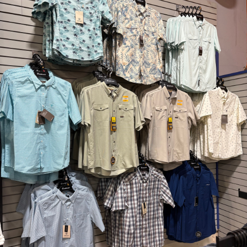 Shirts hung up on clothing racks inside of Rainbow Ag.