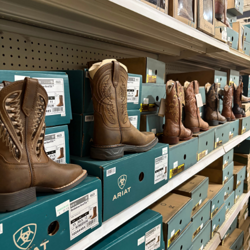 Boots and footwear placed on shelves inside of Rainbow Ag.