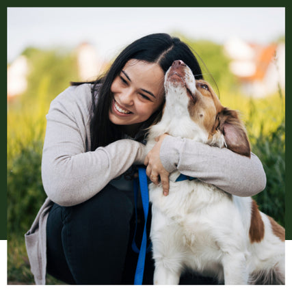 Pet Food & SuppliesAn owner hugging her dog on a clear day.