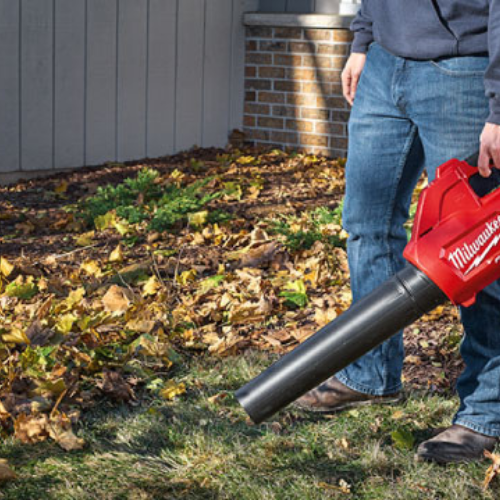 A Milwaukee leaf blower being used on a yard.